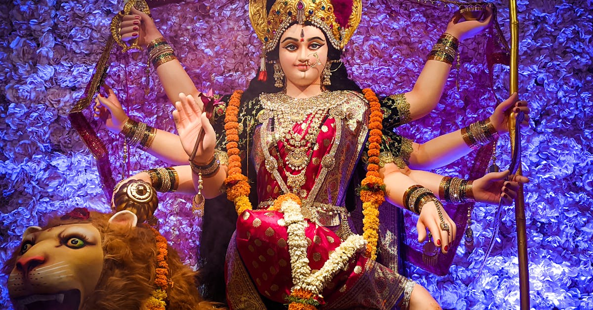 A colorful statue of Goddess Durga during the Hindu festival, adorned with flowers and traditional attire.