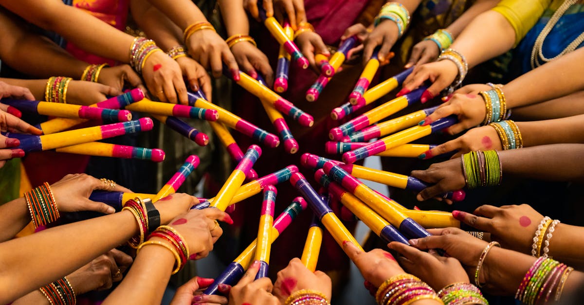Colorful display of hands with dandiya sticks celebrating Navratri festival, showcasing Indian culture.