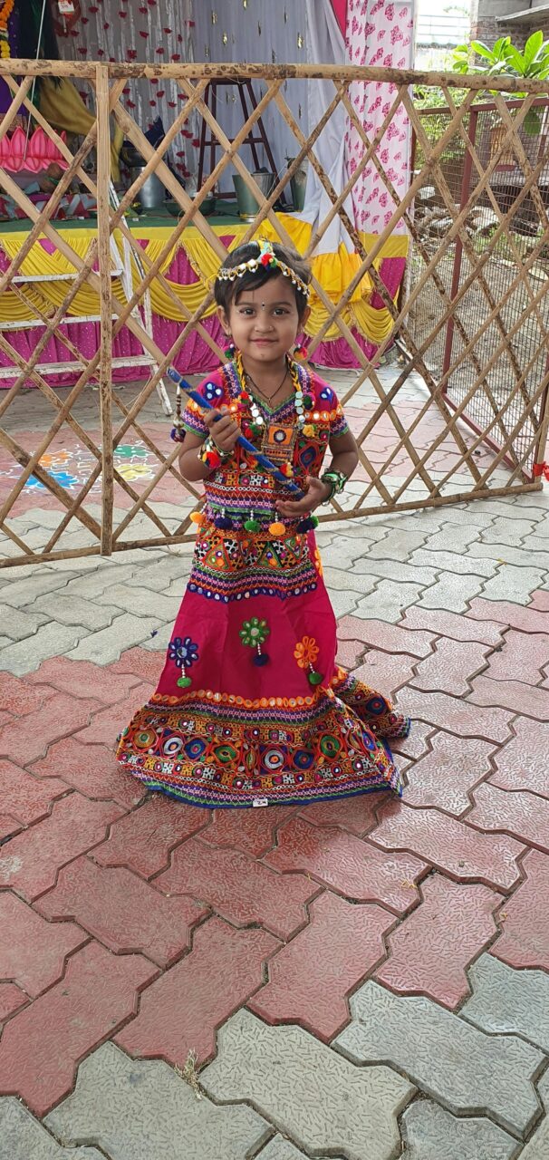 A young girl in a vibrant lehenga celebrates an Indian festival, showcasing traditional attire and cultural heritage.