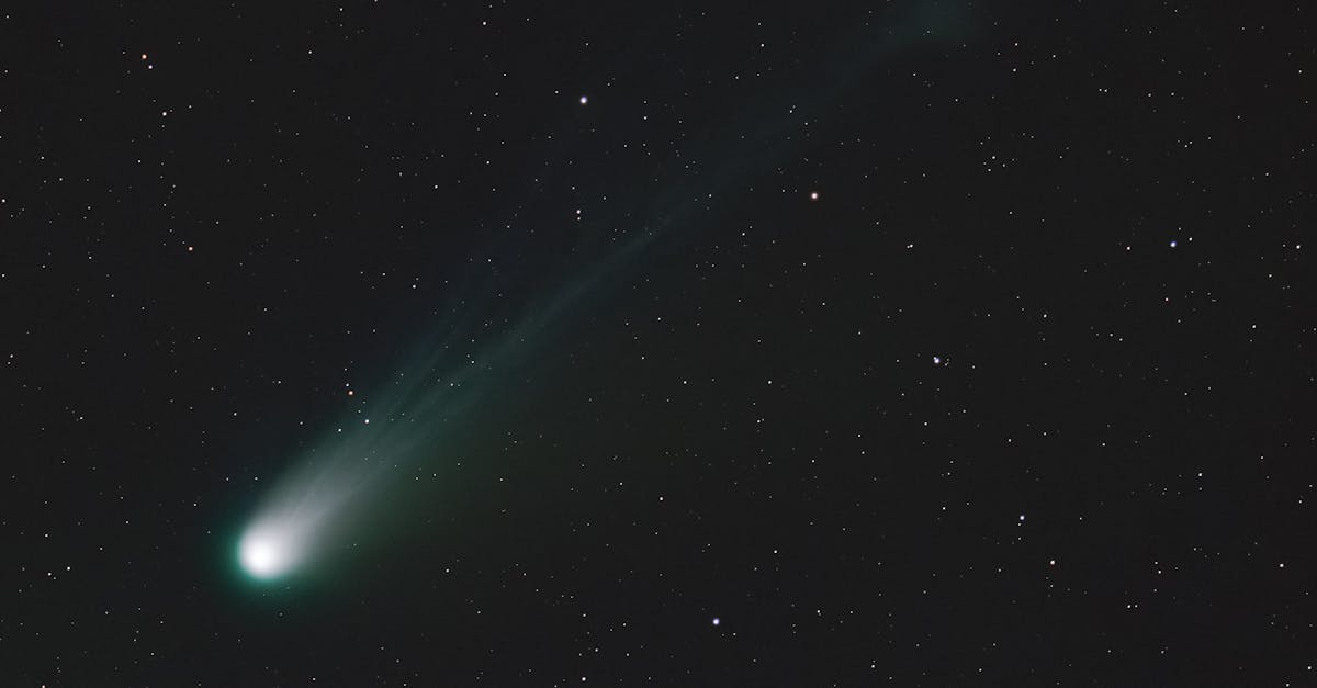 A breathtaking view of a bright comet trailing through the night sky amidst numerous stars.