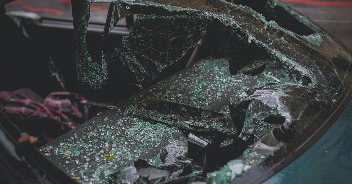 Detailed view of shattered car windshield after accident, emphasizing damage and broken glass.
