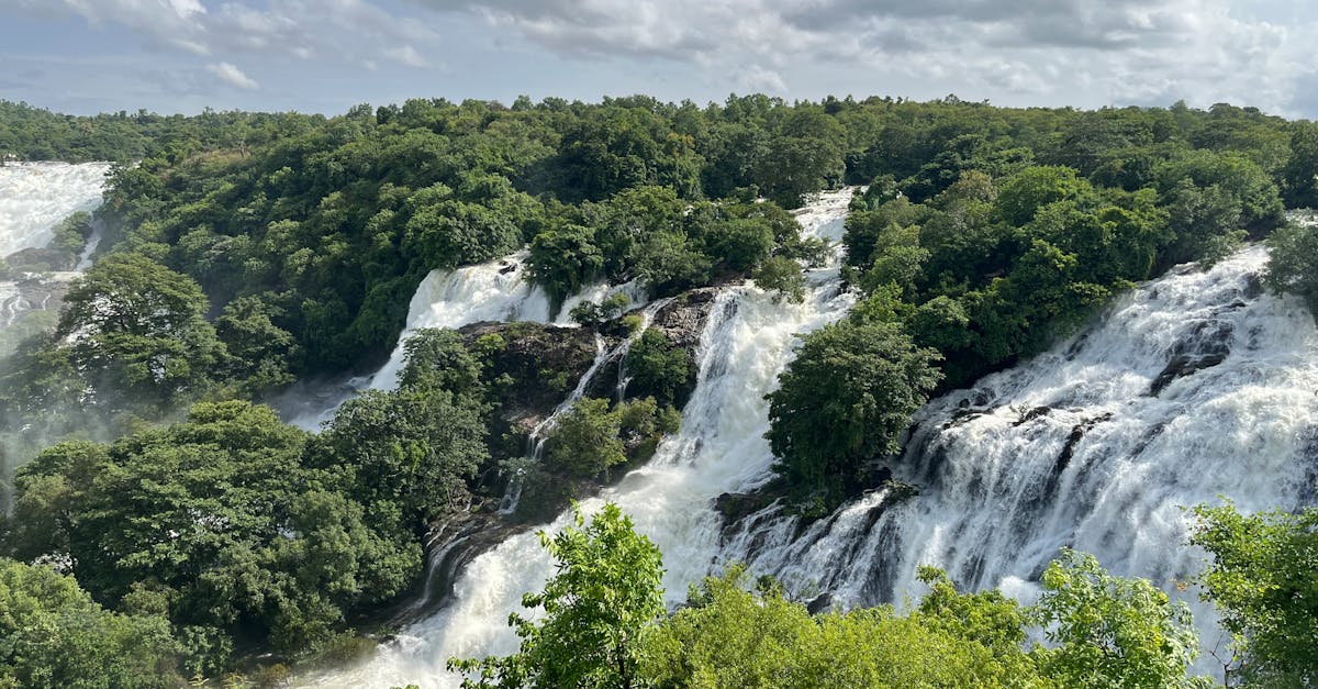 Breathtaking view of cascading waterfalls amidst dense greenery in Chamarajnagar, India.