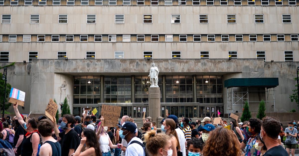 Crowd demonstrating outside a Supreme Court building with placards and slogans.