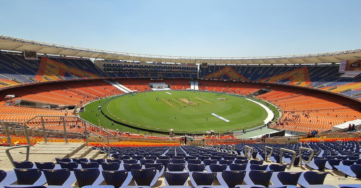 Wide shot of graffiti-adorned Narendra Modi Stadium, highlighting its expansive seating and cricket field.