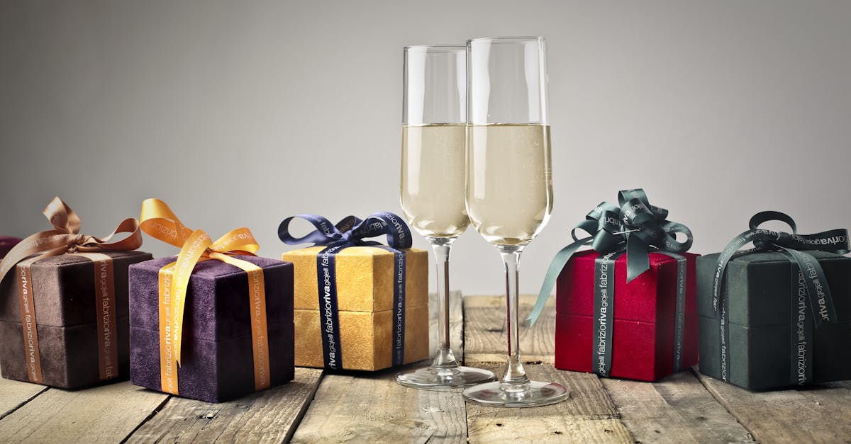 Luxurious gifts with ribbons and champagne flutes on a wooden table, perfect for celebrations.