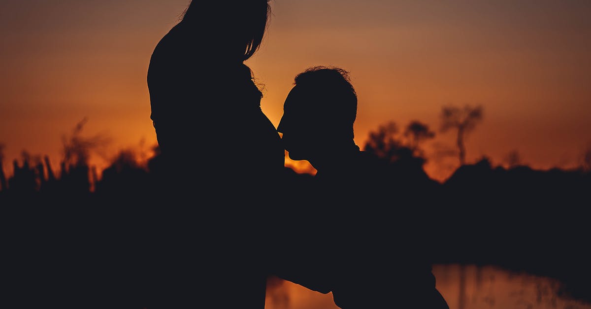 Silhouette of a couple celebrating pregnancy at sunset, capturing a romantic and precious moment.