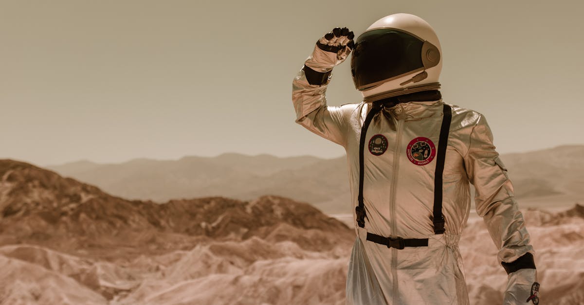An astronaut in a silver spacesuit explores a rocky desert landscape, suggesting a sci-fi theme.