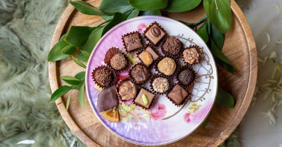 Delicious assortment of gourmet chocolates elegantly arranged on a floral-patterned plate, perfect for dessert lovers.